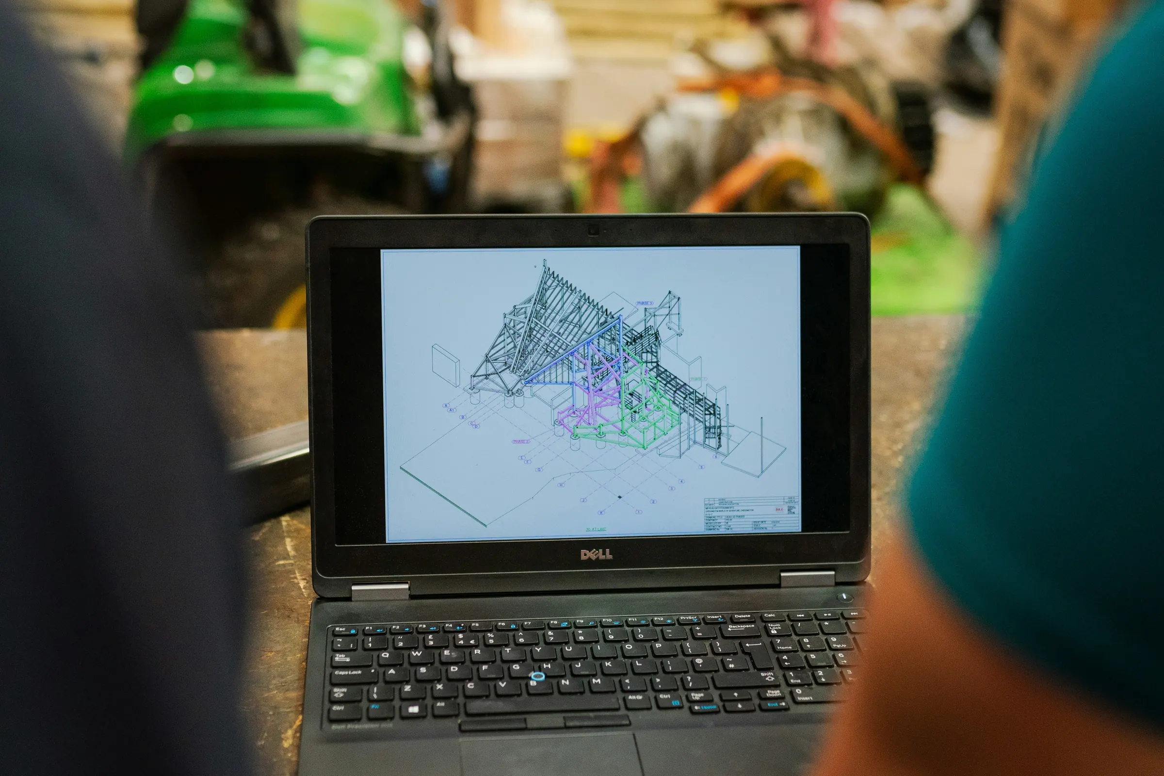 Engineers reviewing a digital design on a laptop in a workshop