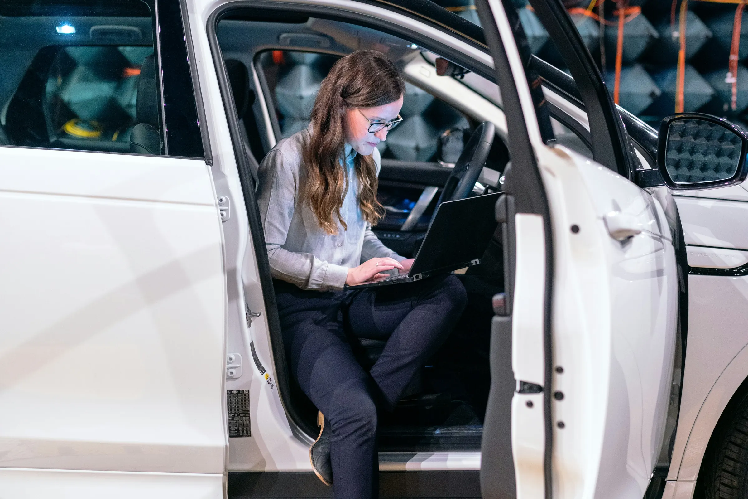 Engineer testing a vehicle in an automotive development facility