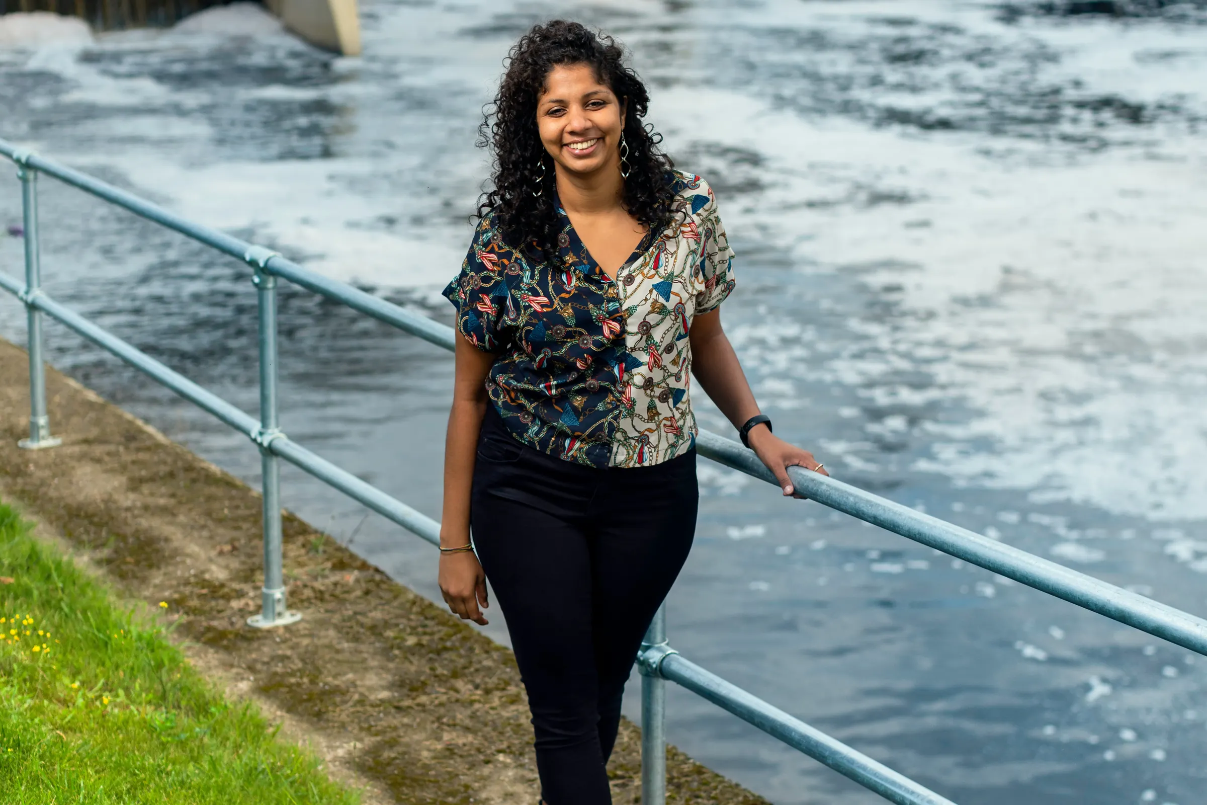 Engineer standing beside a water treatment and renewable energy facility